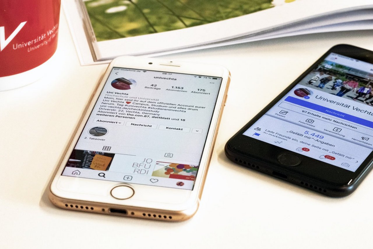Wissenstransfer (Universität Vechta/Siemer) Smartphones auf dem Tisch liegend mit Social Media Kanälen der Universität Vechta.