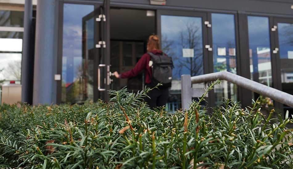 Offene Hochschule (Leier/Universität Vechta) Studentin geht durch den Haupteingang der Universität